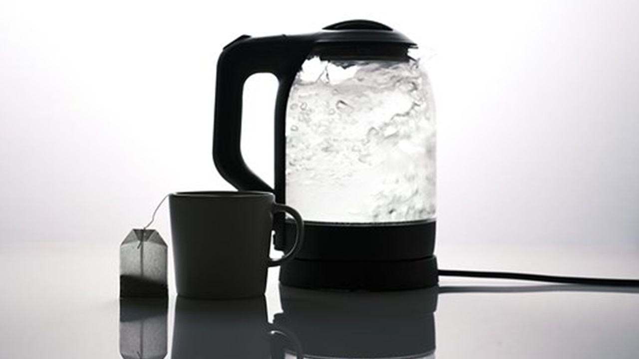 boiled water in the kettle and a cup are placed on the table